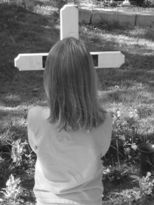 Praying at grave Charlotte Criminal Lawyer Mecklenburg Defense Attorney